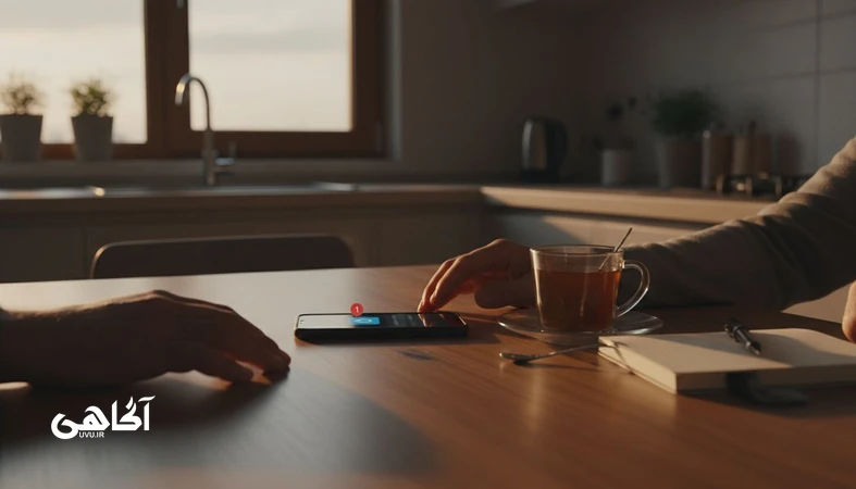 تصویر مکث چند ثانیه‌ای قبل از واکنش کنار گوشی و چای در فضای خانه؛ مجله آگاهی