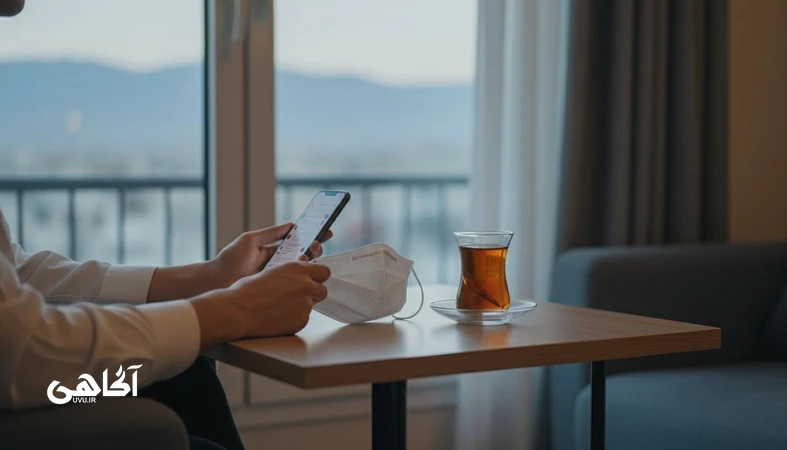 تصویر مفهومی زندگی نمایشی و فاصله درون و بیرون در مجله آگاهی؛ دستی که ماسک اجتماعی را کنار تلفن همراه روی میز گذاشته است